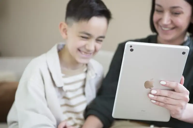 Happy mom and son with Penta Power Duo Tag on tablet
