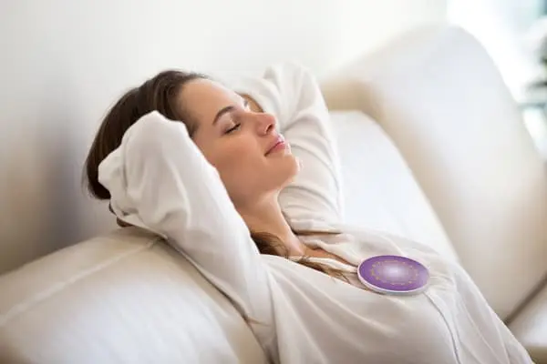 Quantum Booster sur la poitrine d'une femme assise dans un fauteuil regardant devant elle